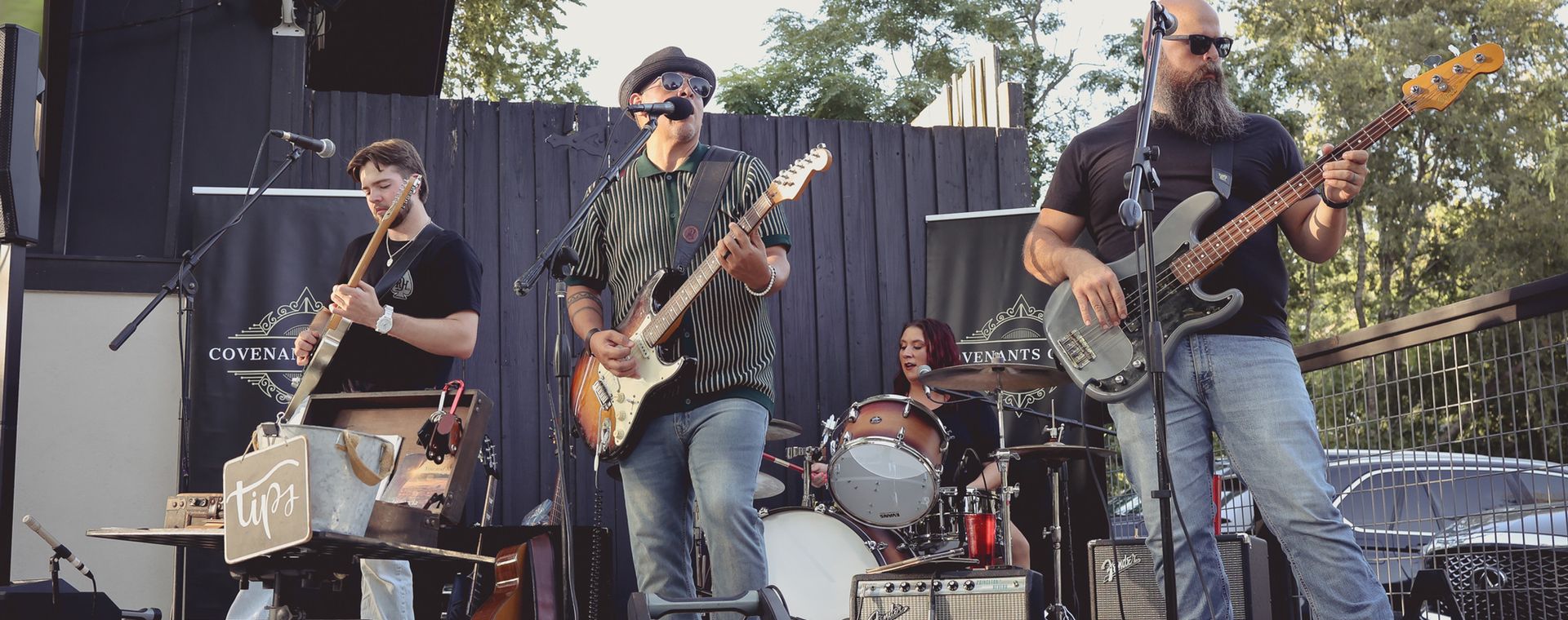 Andy Garcia playing electric guitar on an outdoor stage with his band